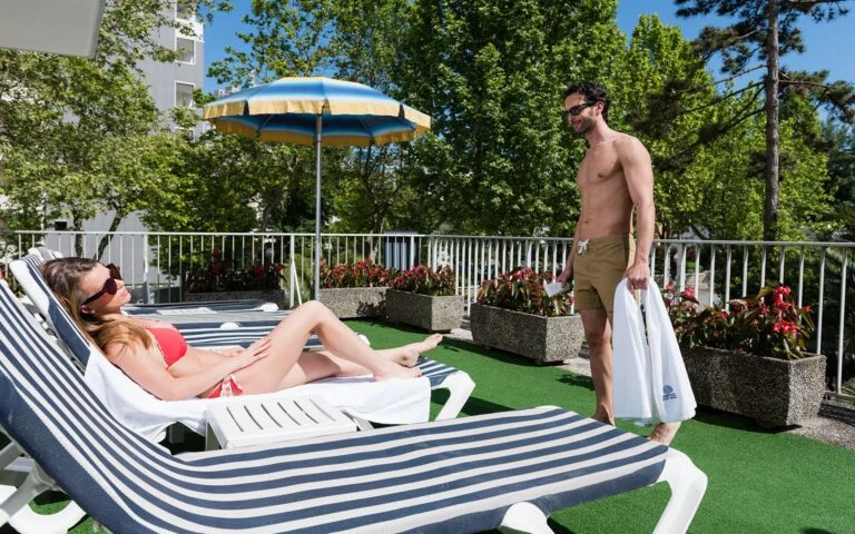 Coppia che prende il sole nel giardino dell'Aparthotel Pineda